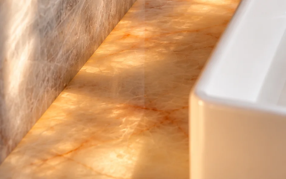 Frontão em L do lavatório em Quartzito Cristal Translúcido retroiluminado, feito pela Marmoraria Efraim
