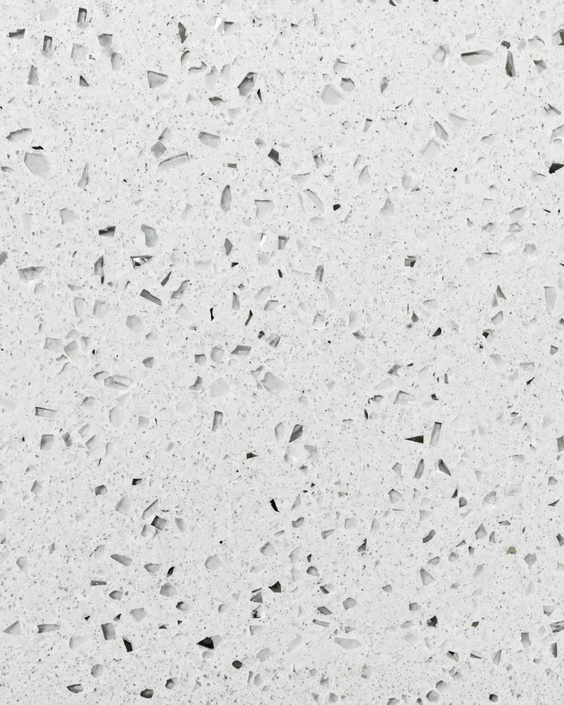 Quartzo Branco Stellar polido de perto: fundo branco com lascas translúcidas e espelhadas e pontos cinza